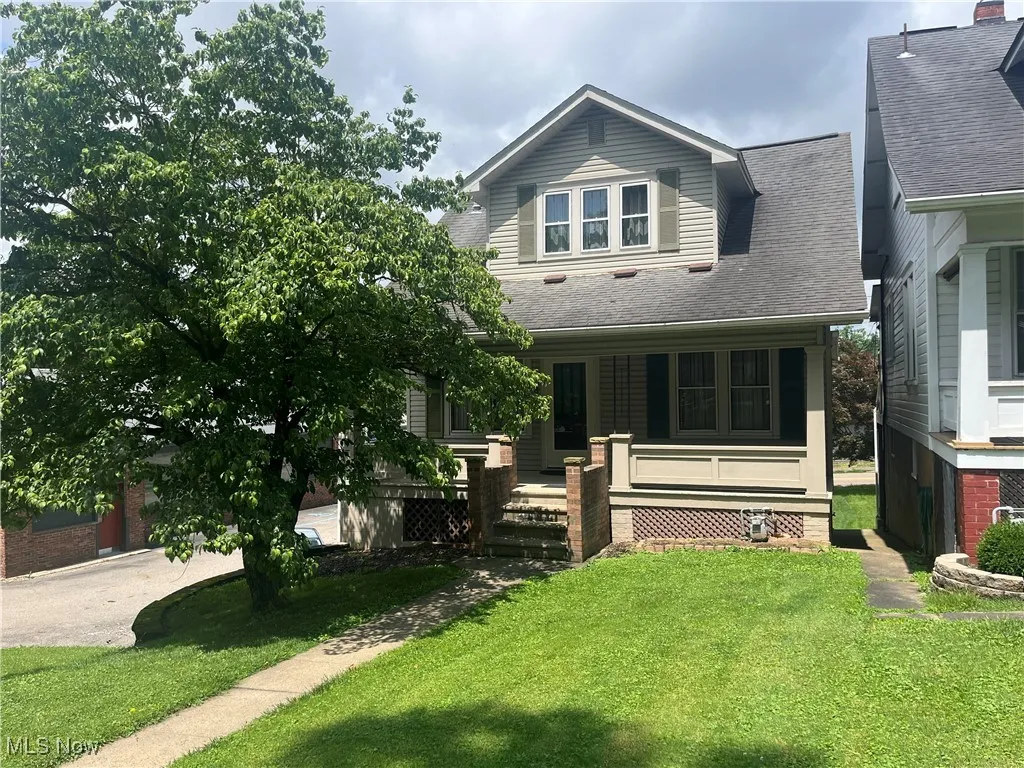 View of front facade featuring a front yard, covered porch.