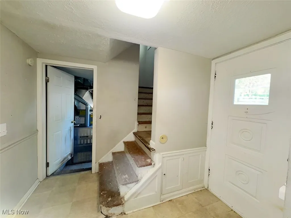 Foyer entrance with stairway and a textured ceiling