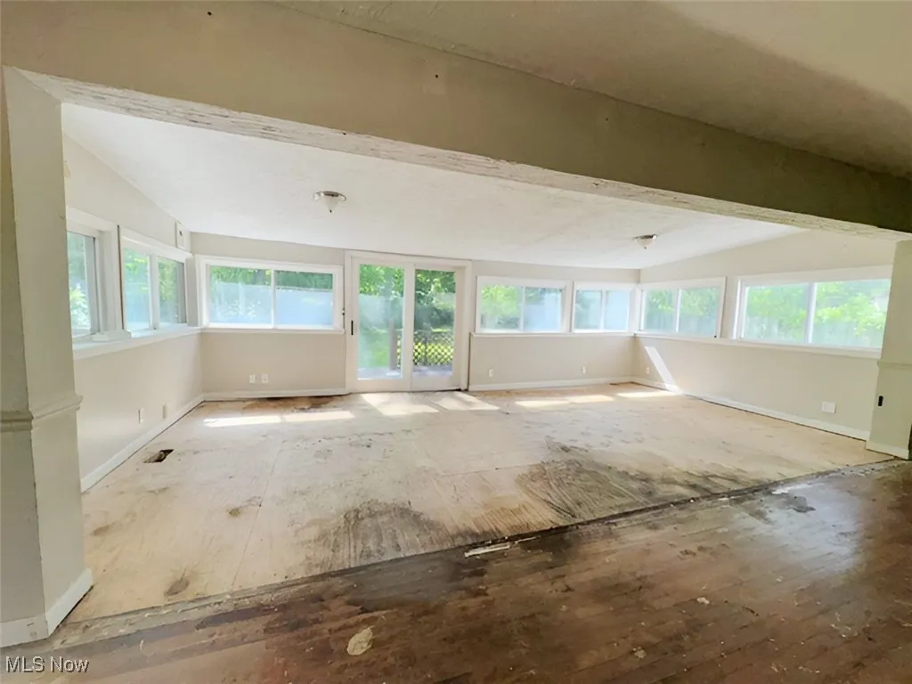 Empty room with lofted ceiling and baseboards