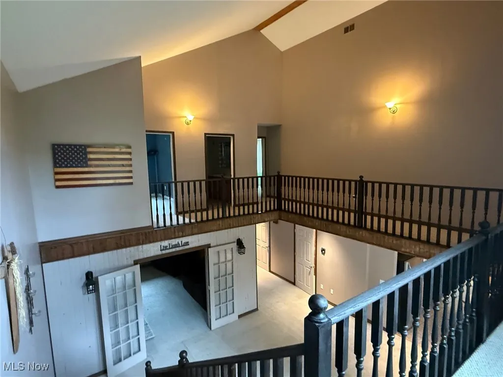Stairs with high vaulted ceiling and carpet
