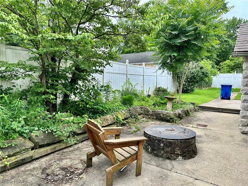 Fenced backyard with a fire pit and a patio