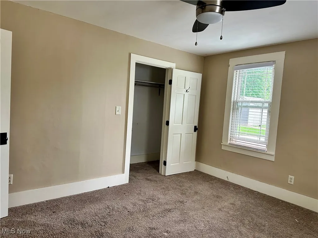 Unfurnished bedroom with carpet flooring, a ceiling fan, and a closet