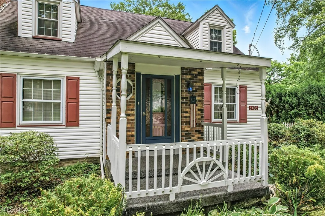 Doorway to property with covered porch and roof with shingles