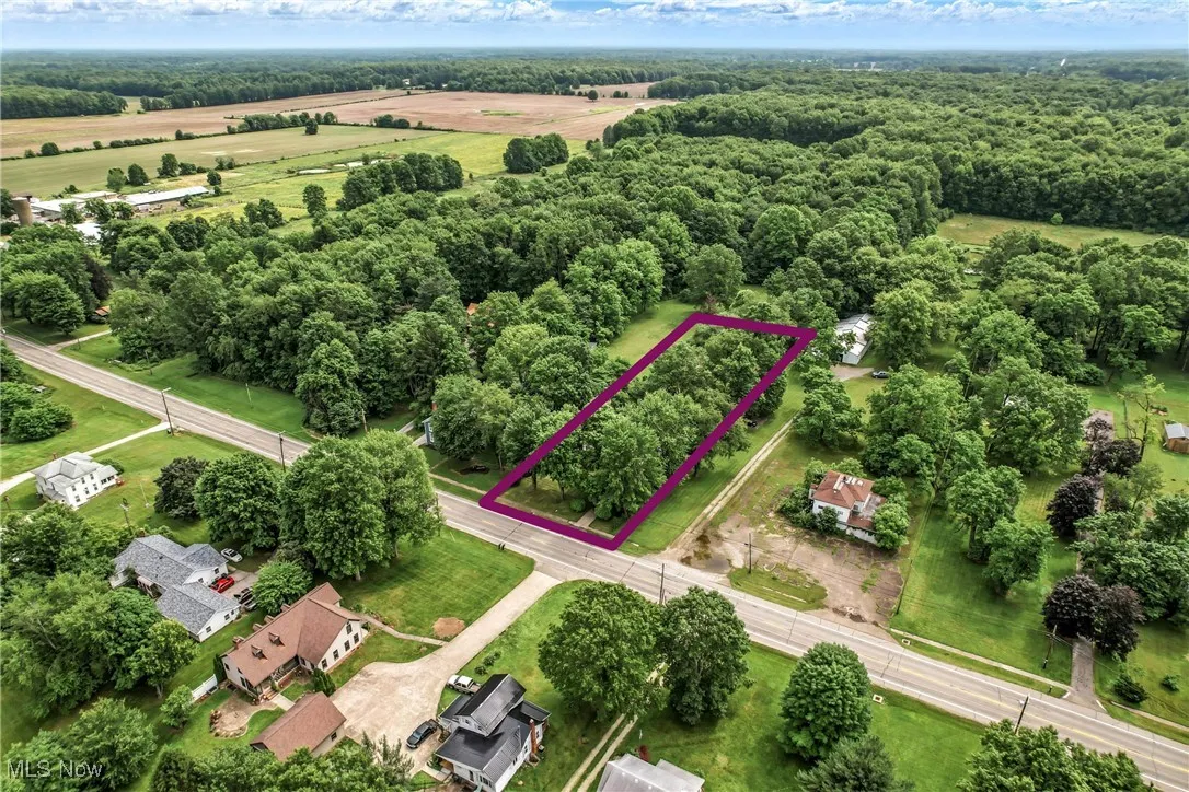 Aerial overview of property's location featuring property parcel outlined and a heavily wooded area