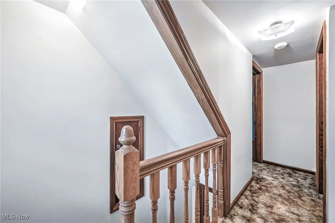 Hallway featuring an upstairs landing and carpet