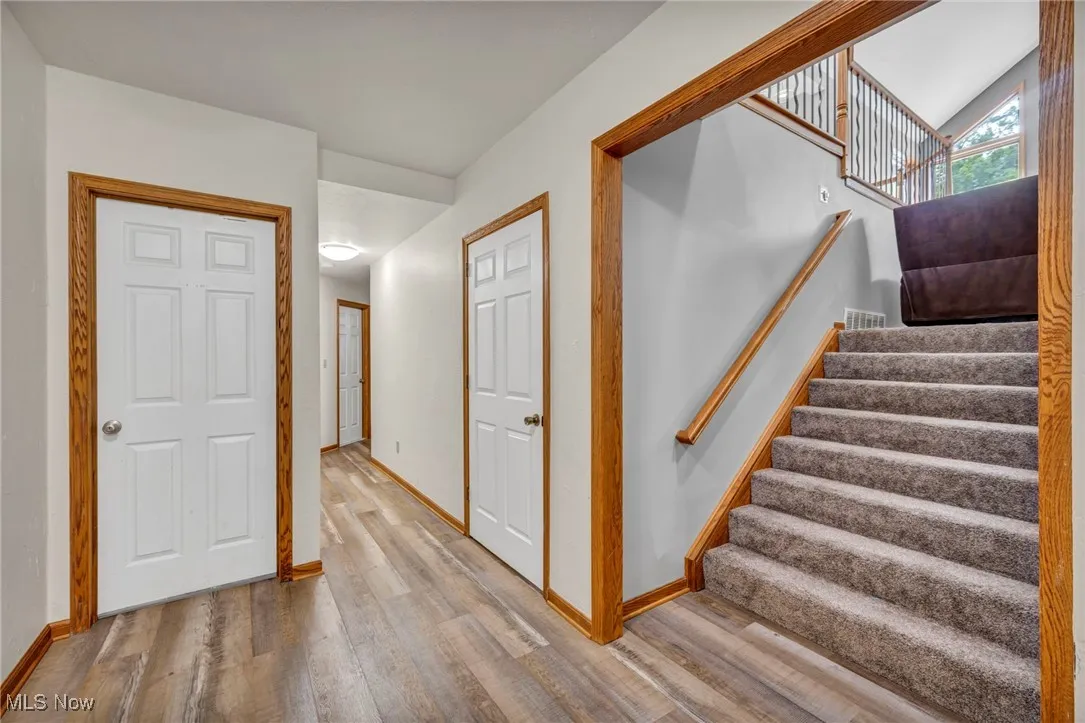 Stairway featuring wood finished floors and baseboards headed into lower level
