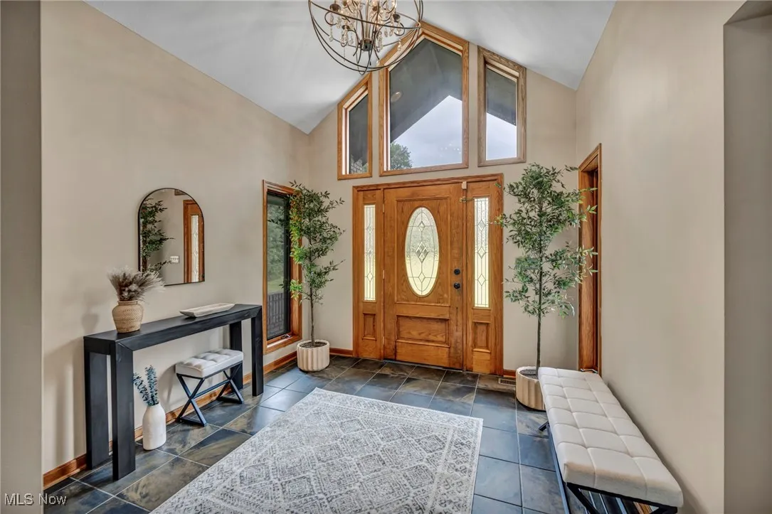 Foyer entrance featuring high vaulted ceiling and a chandelier
