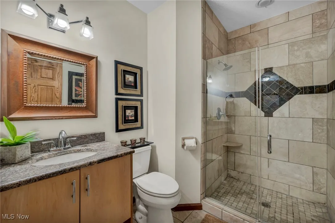 Full Bathroom featuring vanity, a stall shower, and tile patterned flooring first level