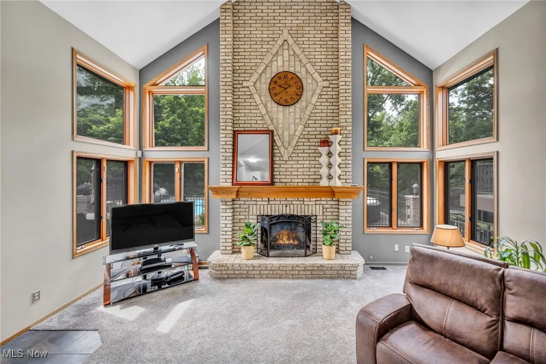 Grate room featuring high vaulted ceiling, carpet flooring, and gas fireplace