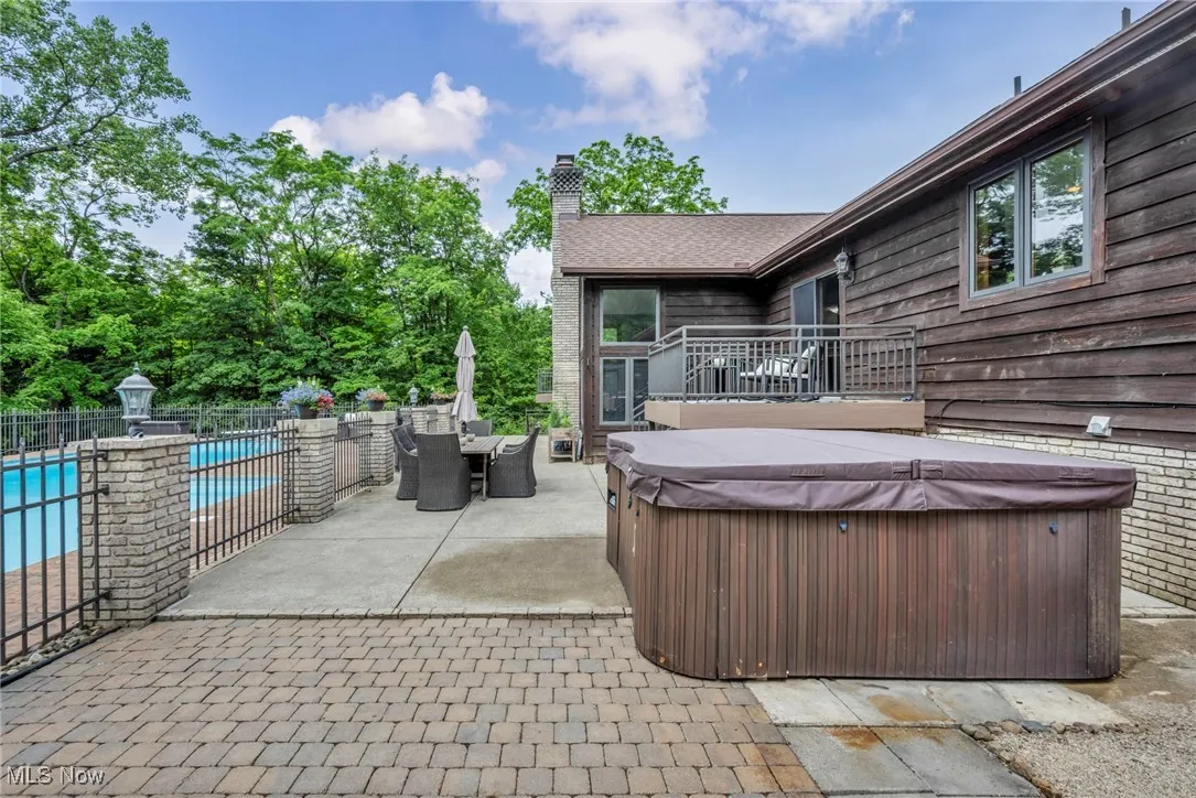 View of patio / terrace with a hot tub and outdoor dining space
