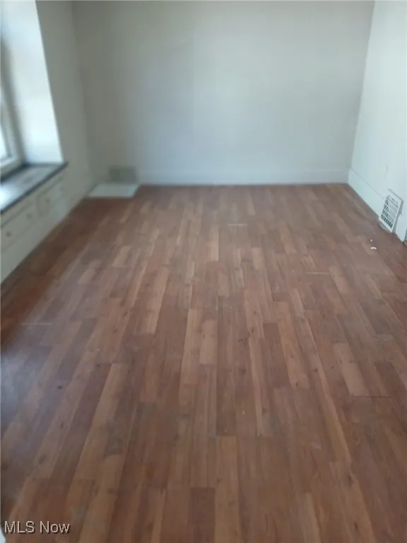 Unfurnished room with dark wood-style floors