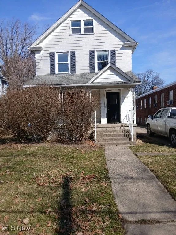 American foursquare style home with a front yard