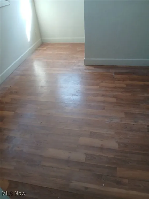 Spare room with baseboards and wood finished floors