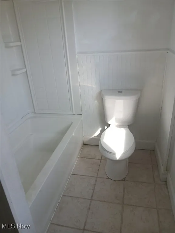 Full bath featuring wainscoting and tub / shower combination