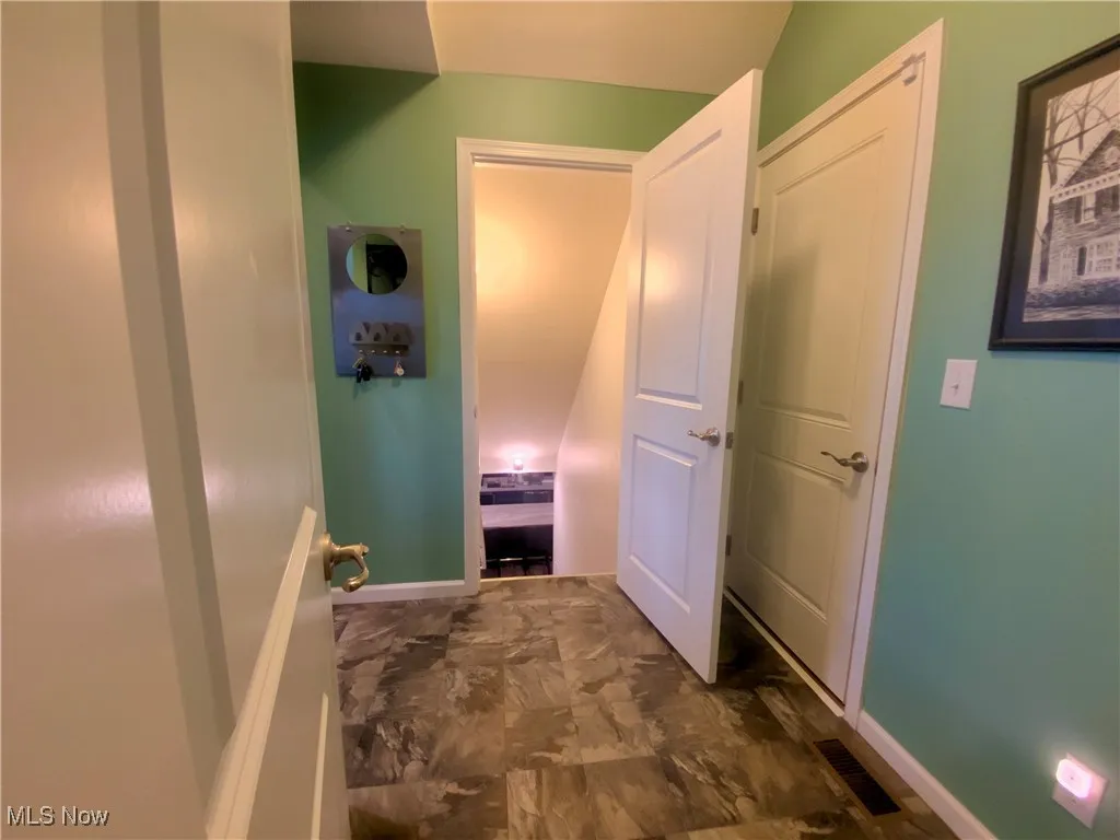 The stairway from the mudroom leads down to the lower level, offering easy access to additional living space, whether it’s for entertaining, extra storage, or a cozy retreat.