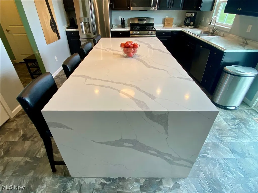 The heart of the home is the magnificent kitchen, featuring a stunning 8 ft by 4 ft island that comfortably seats 4—perfect for casual meals or gathering with friends. The luxurious quartz countertop, with a striking waterfall edge crafted from a single slab, adds a touch of elegance and sophistication to the space.