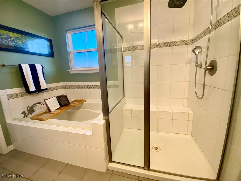 The primary en-suite bathroom offers the ultimate in relaxation, featuring a spacious shower equipped with a rainfall showerhead and a handheld option, alongside a luxurious soaking tub. Whether you crave a quick refreshing shower or a long, soothing soak, this bathroom provides the perfect balance of comfort, convenience, and indulgence.