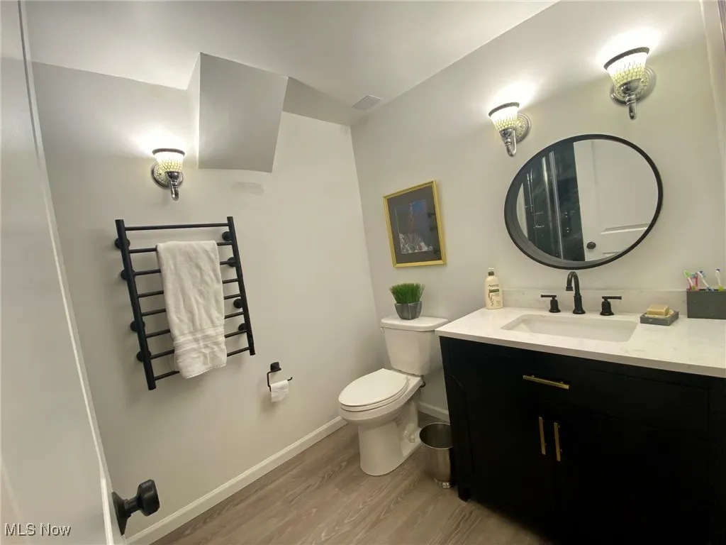 The lower-level bathroom offers generous space and features a sleek granite countertop, combining comfort with a touch of luxury.