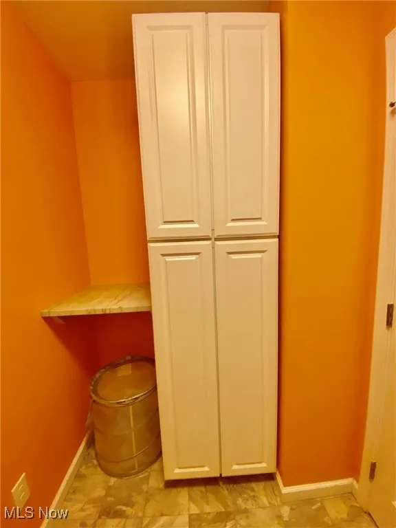 The laundry room features a tall cabinet with a sleek granite countertop, offering both abundant storage and a stylish surface for folding or sorting laundry. It’s the perfect blend of practicality and elegance, adding extra convenience to this essential space.