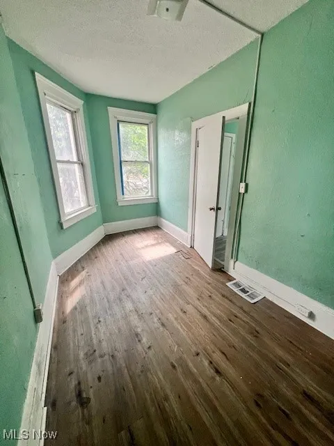 Unfurnished bedroom featuring wood-type flooring and a textured ceiling