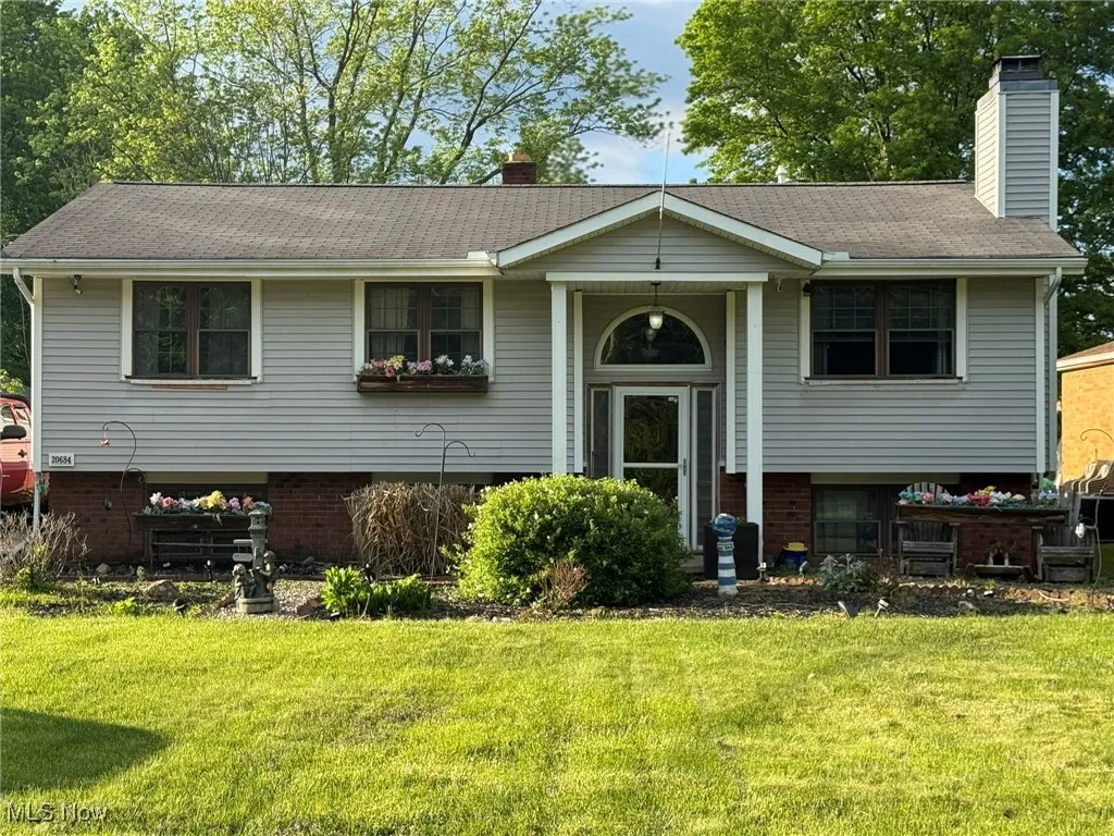 Bi-Level featuring a chimney, a front yard, and brick siding