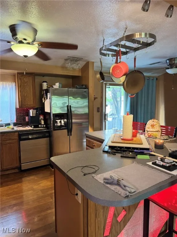 Kitchen featuring appliances with stainless steel finishes, ceiling fan, a textured ceiling, and healthy amount of natural light