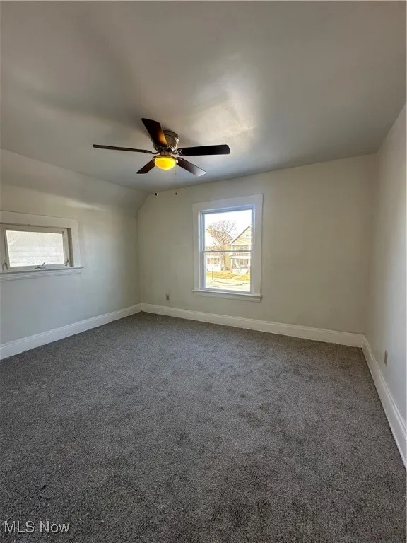Unfurnished room featuring carpet floors, plenty of natural light, and ceiling fan