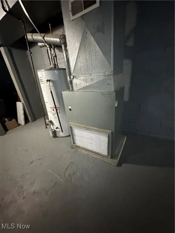 Utility room featuring water heater and heating unit