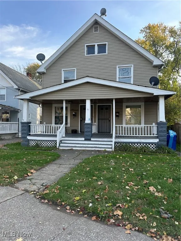 American foursquare style home with covered porch and a front yard