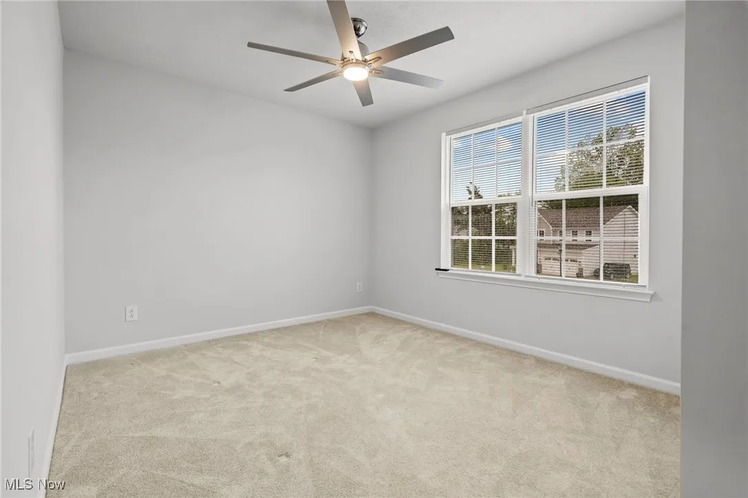 Unfurnished room with carpet flooring and a ceiling fan