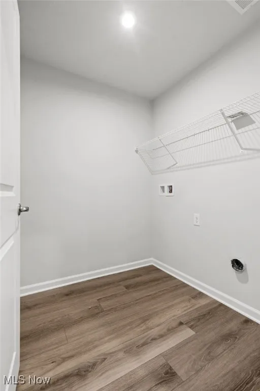 Laundry area with wood finished floors, washer hookup, and recessed lighting
