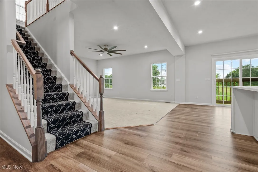 Foyer with wood finished floors, recessed lighting, plenty of natural light, stairway, and ceiling fan