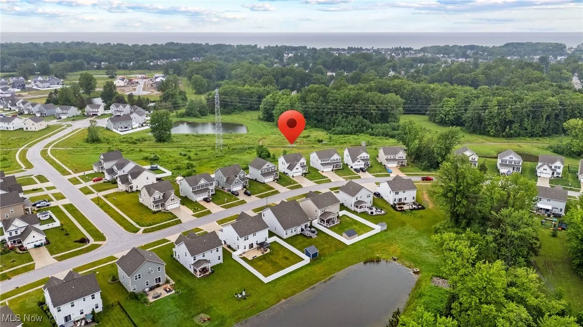 Aerial view of property and surrounding area with a large body of water and nearby suburban area