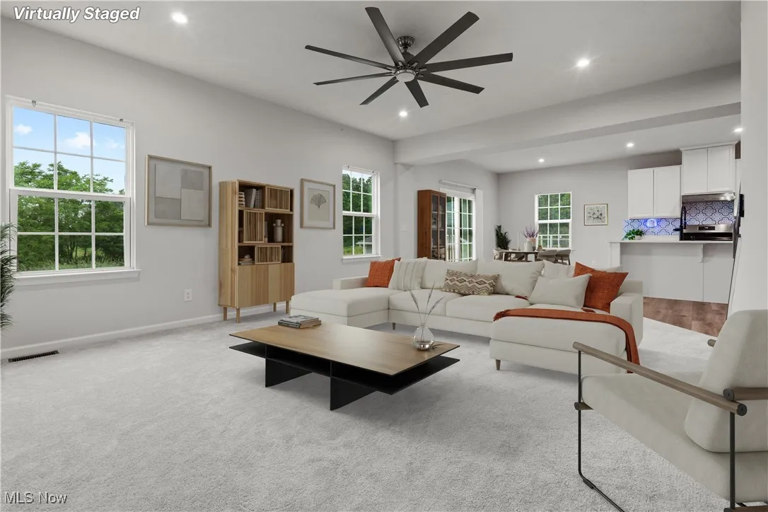 Living area with recessed lighting, healthy amount of natural light, ceiling fan, and carpet