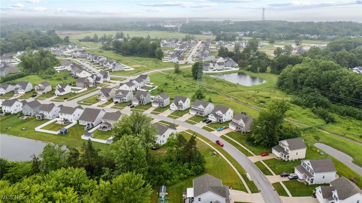 Aerial view of property's location featuring a large body of water and nearby suburban area