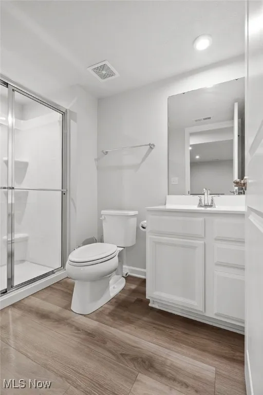 Full bath with vanity, wood finished floors, and a shower stall