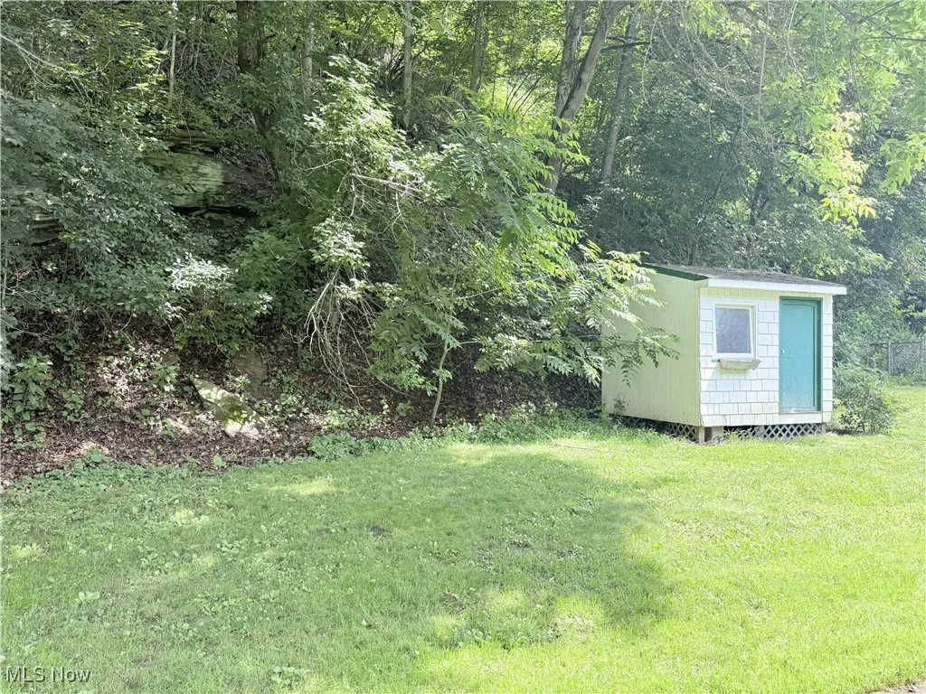 View of green lawn featuring a storage shed