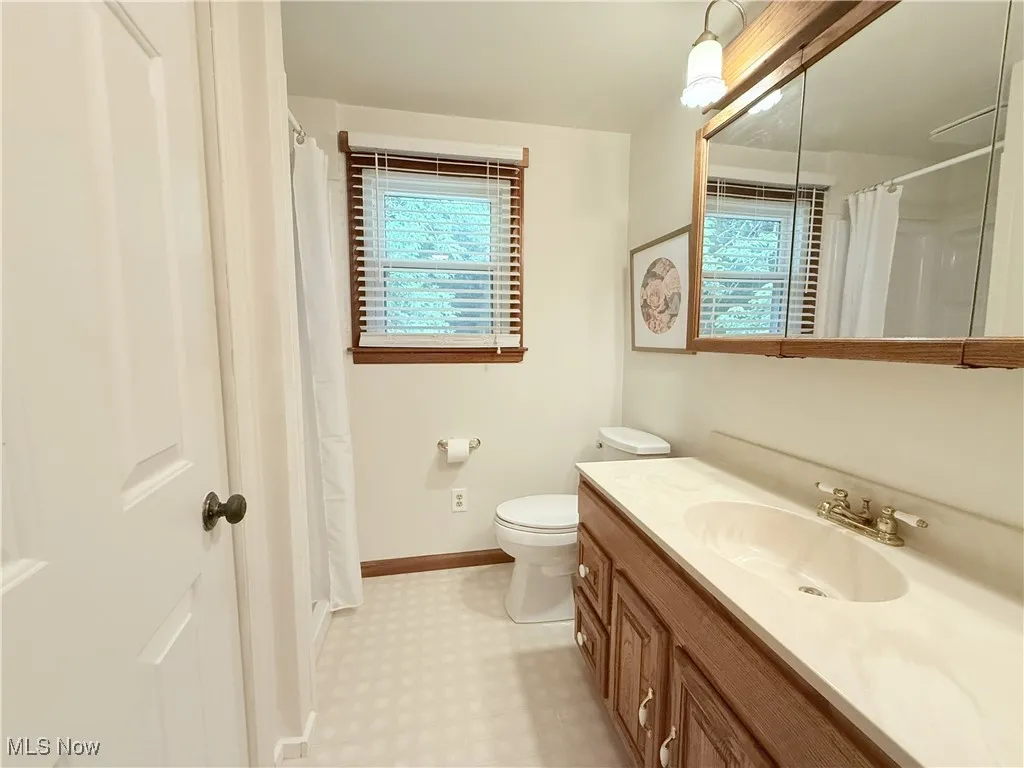 Full bath featuring vanity, a shower with shower curtain, and tile patterned floors