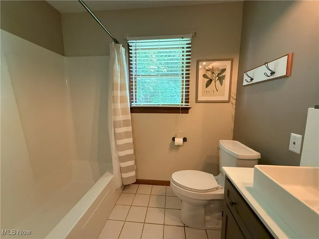 Full bathroom featuring vanity, tile patterned flooring, and shower / bath combination with curtain