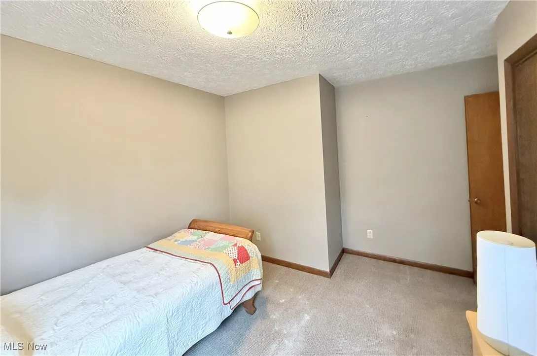 Bedroom featuring carpet floors and a textured ceiling