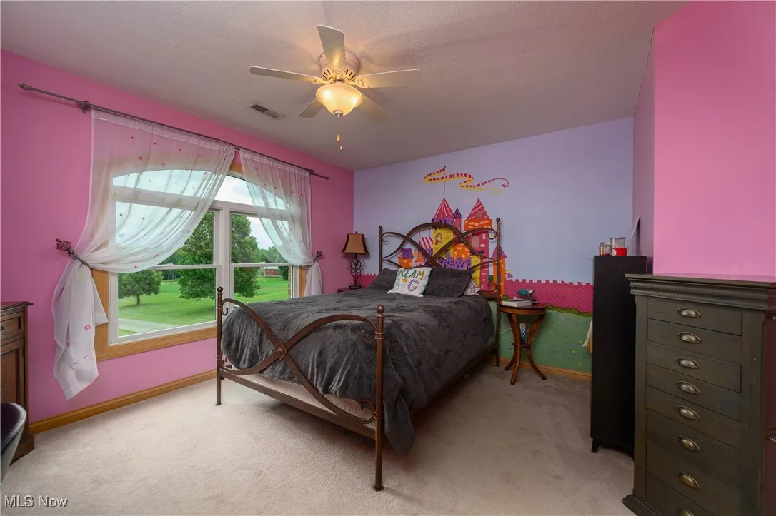 Bedroom with light colored carpet and ceiling fan