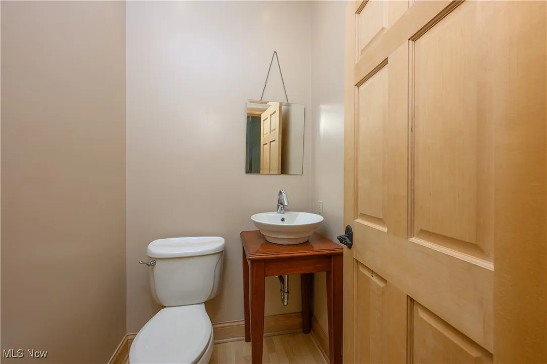 Half bath with a sink and wood finished floors