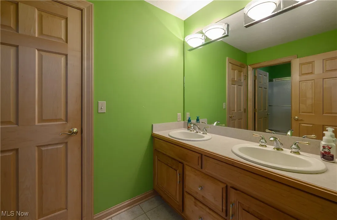 Bathroom with double vanity and tile patterned flooring