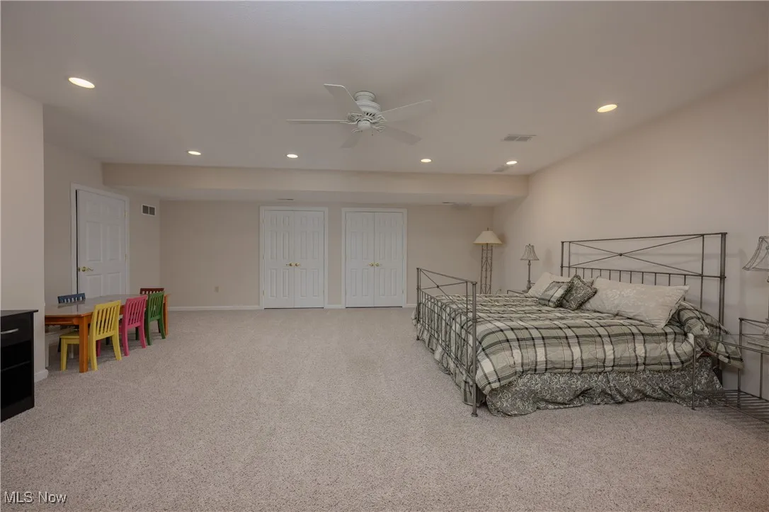 Bedroom with carpet, recessed lighting, multiple closets, and a ceiling fan