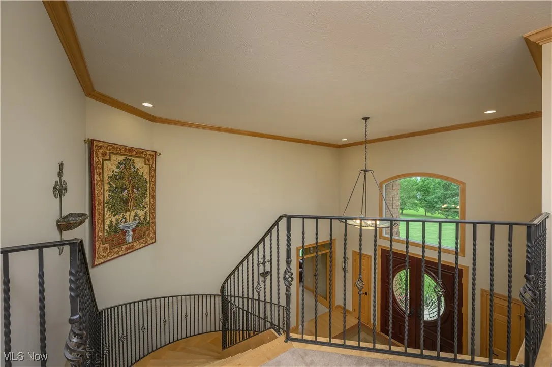 Stairs with recessed lighting and crown molding