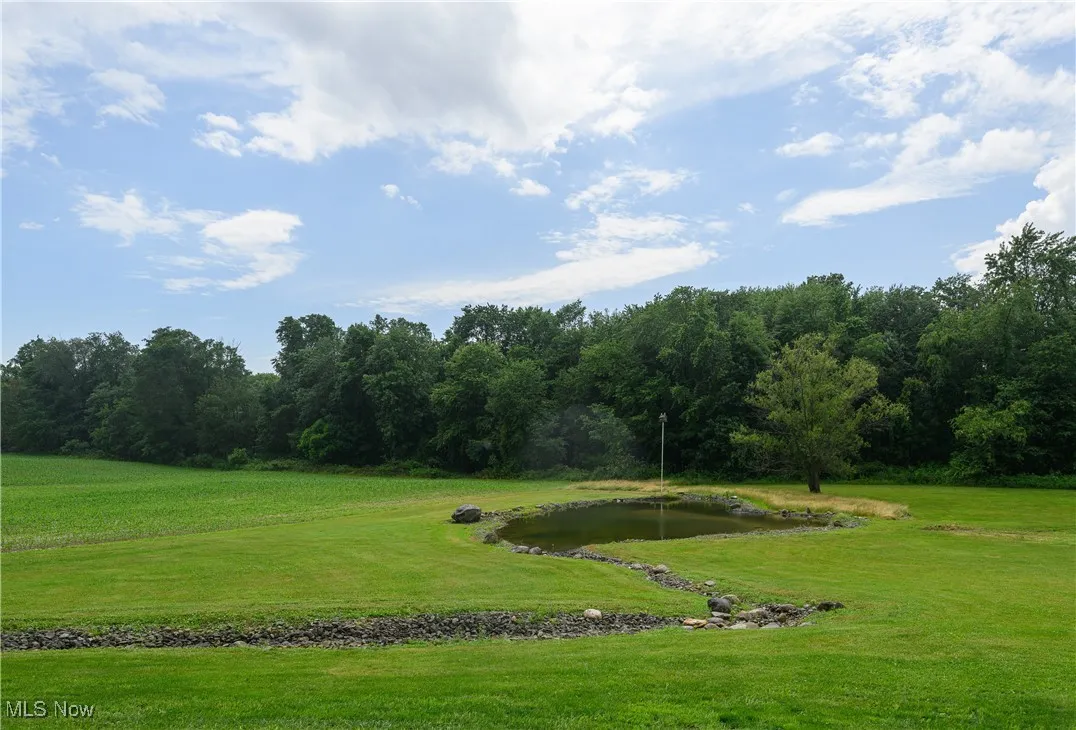 View of home's community featuring a water view, a lawn, and a view of trees
