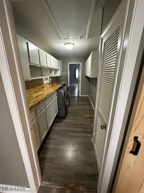 Kitchen featuring butcher block counters and dark wood-style floors