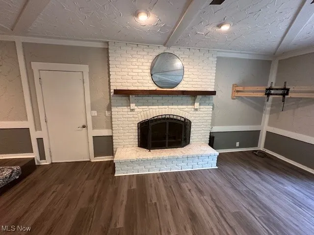 Unfurnished living room featuring wood finished floors and a fireplace