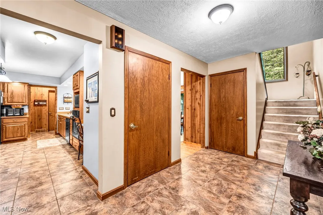 Entryway with stairway and a textured ceiling