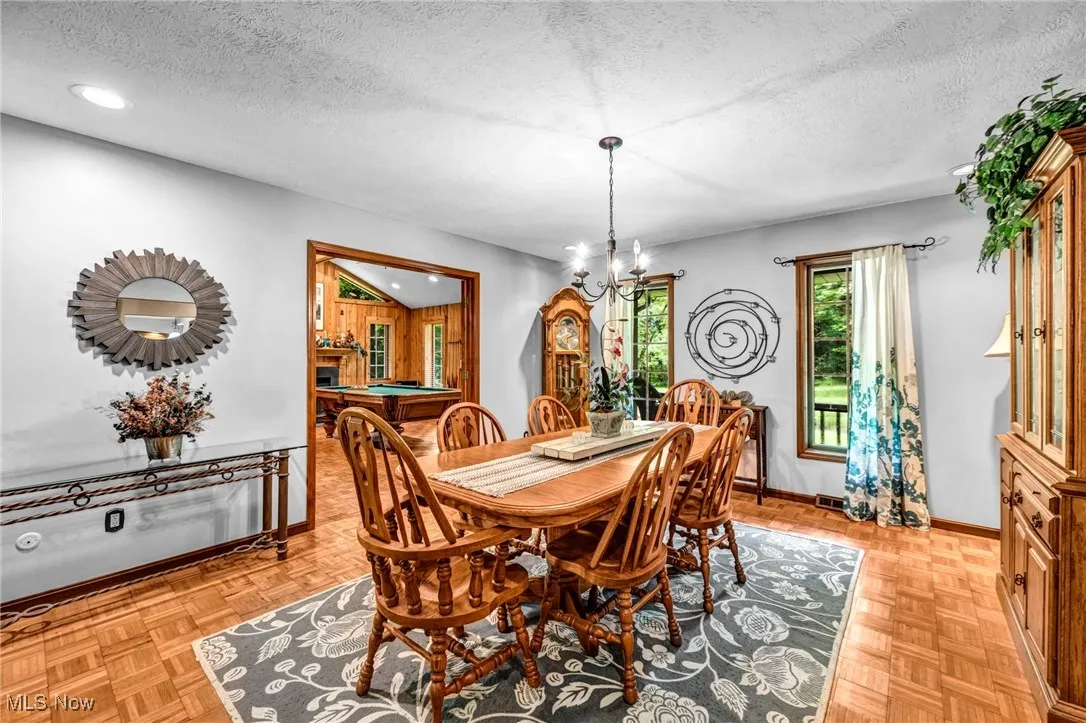 Dining space with a chandelier, a textured ceiling, and recessed lighting